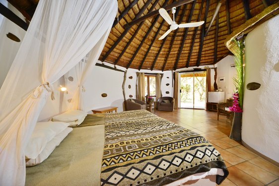 Großzügiges Zimmer mit Bett in der Makutsi Lodge in Südafrika